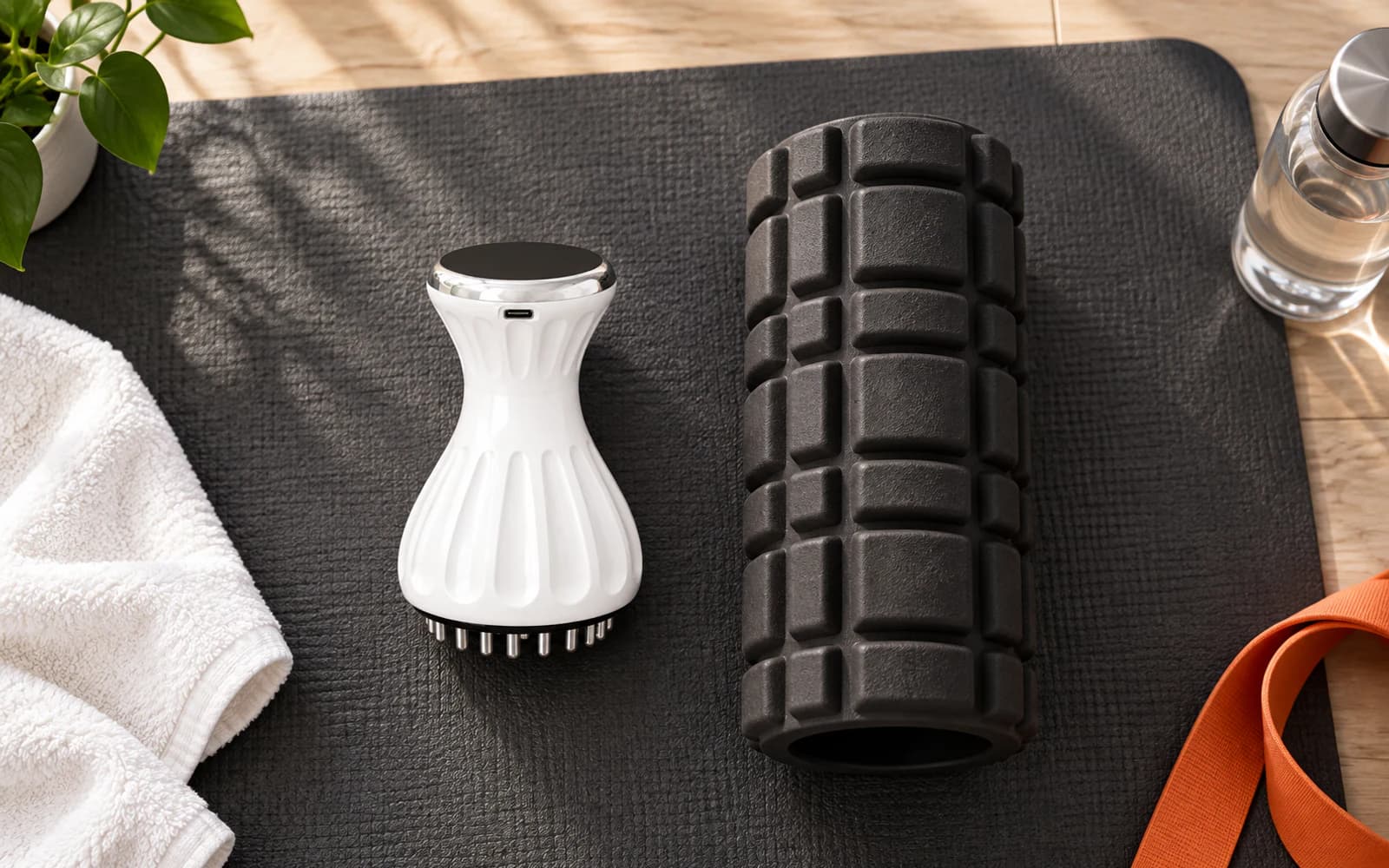 Handheld body massager and foam roller arranged on an exercise mat